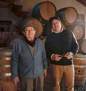 Ein Beispiel aus der Foto-Reportage: Der Winzer und sein Vater stehen vor Weinfässern.